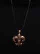 Gold fleur de lis medallion on black vinyl strap